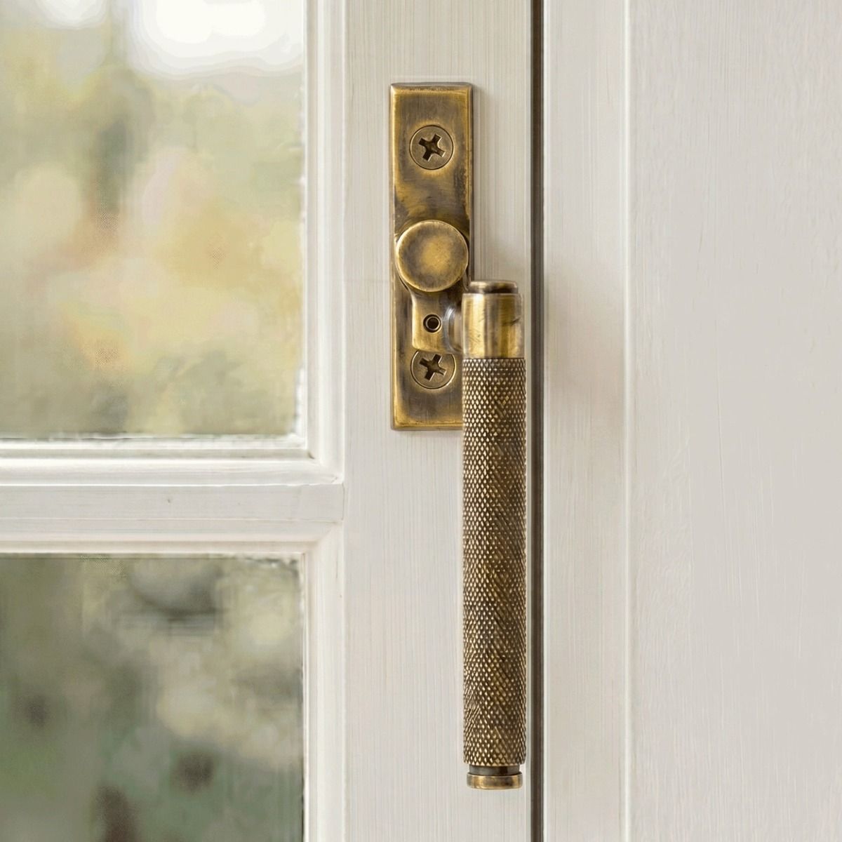 The Right Handed Aged Brass Espag Window Handle Fitted on a Handpainted Window Frame in a Modern Home - Digital Illustration