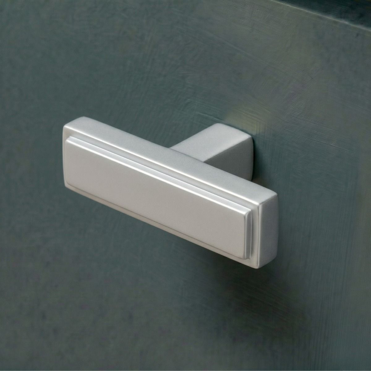 The Satin Chrome "Emerson" Rectangular T-Bar Cabinet Pull Handle Mounted on a Wooden Kitchen Drawer - Digital Illustration