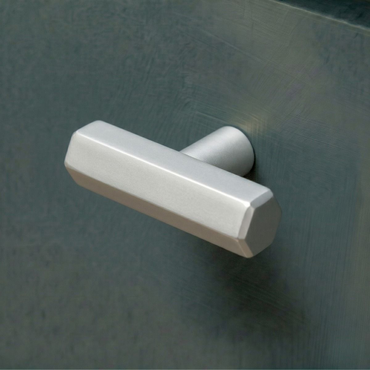 The Polished Nickel "Lexington" Hex T-Bar Cabinet Handle Mounted on a Dark Blue Kitchen Cupboard Drawer - Digital Illustration 