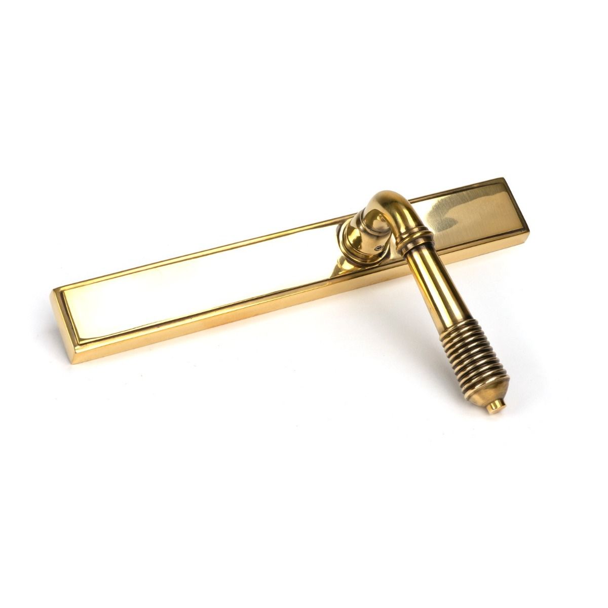 The Slimline Lever Espagnolette Door Latch in Aged Brass Lying on its Side on a White Background