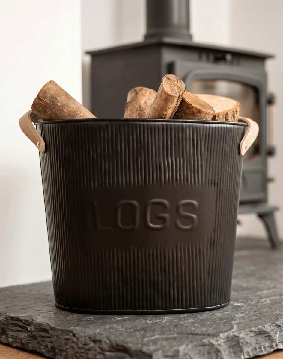 The Small Black Steel "Fire Wood" Log Basket filled with Logs next to a Traditional Black Wood Burner Stove - Digital Illustration
