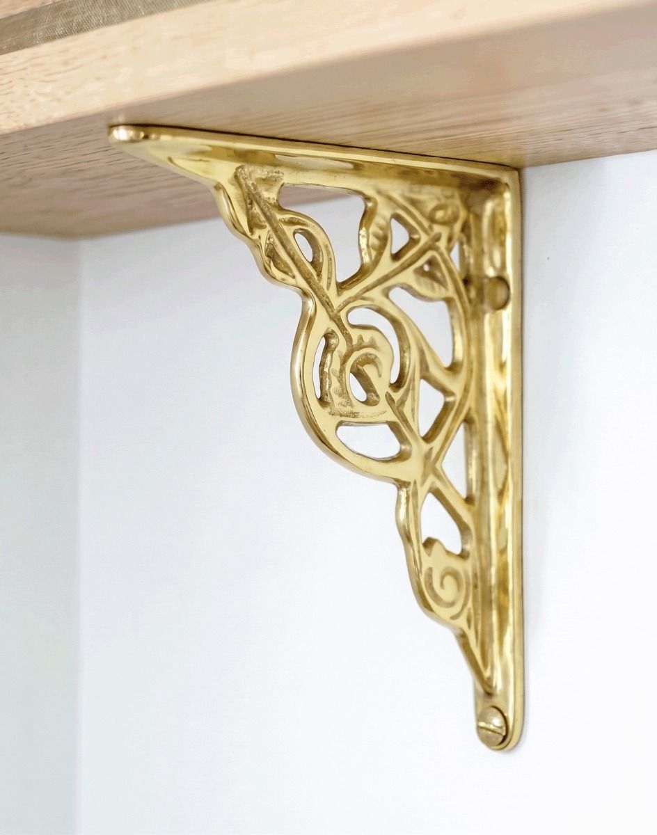 The Small Trellis Brass Shelf Bracketin Polished Brass Mounted on a White Coloured Modern Interior wall - Digital Illustration 