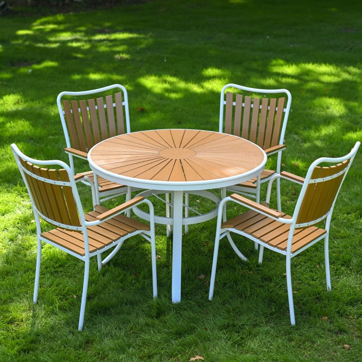 The Solis Round 4-Seater Outdoor Dining Set in White Pictured on a Lush Green Lawn