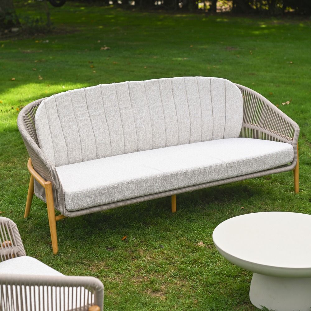 The Soria Woven 4-Piece Outdoor Lounge Set Showing the Benck on a Shaded Garden Lawn