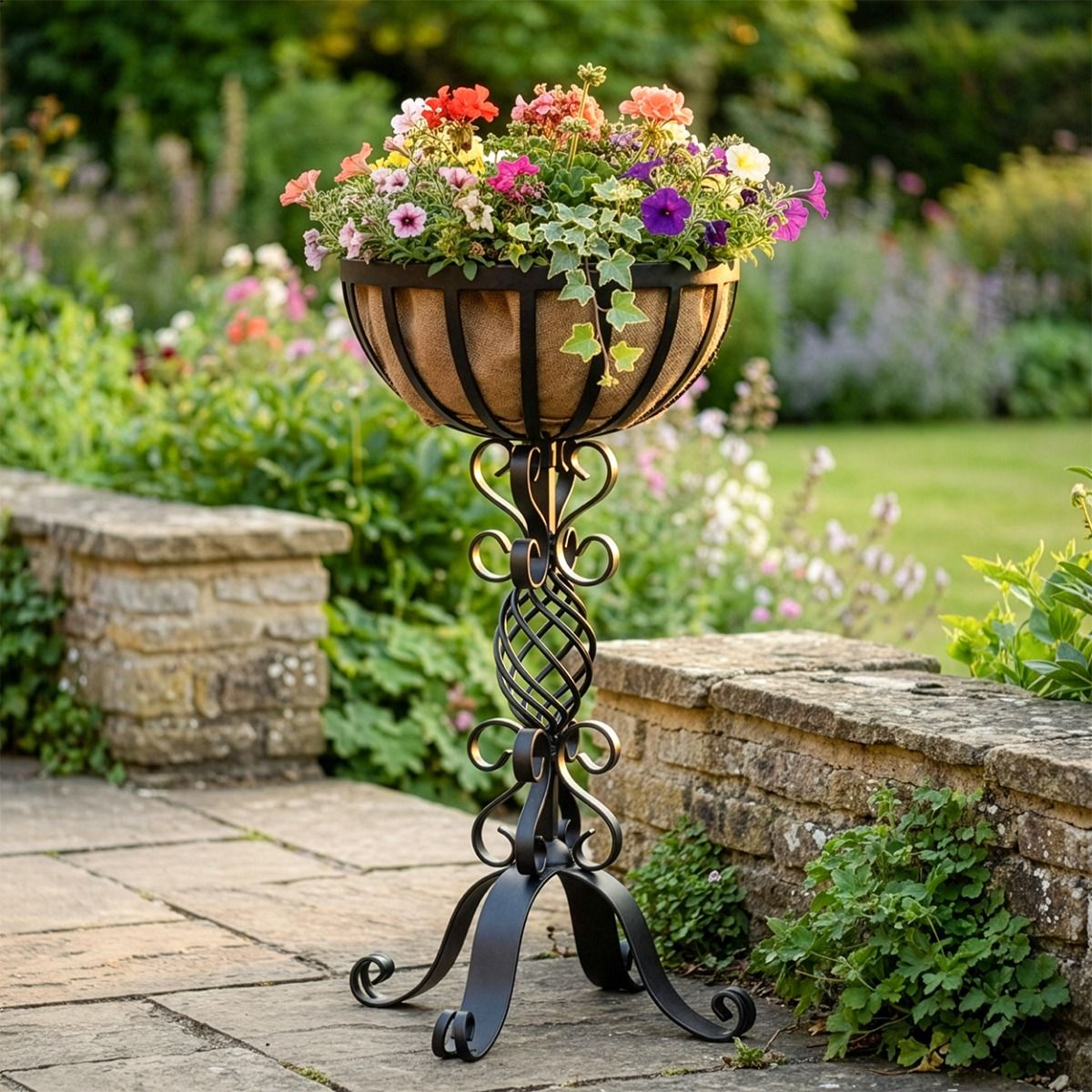 The "Stretton" Victorian Wrought Iron Basket Planter Stand in a Black Finish Positioned in a Low Walled Private Garden with Flowers Planted - Digital Illustration 