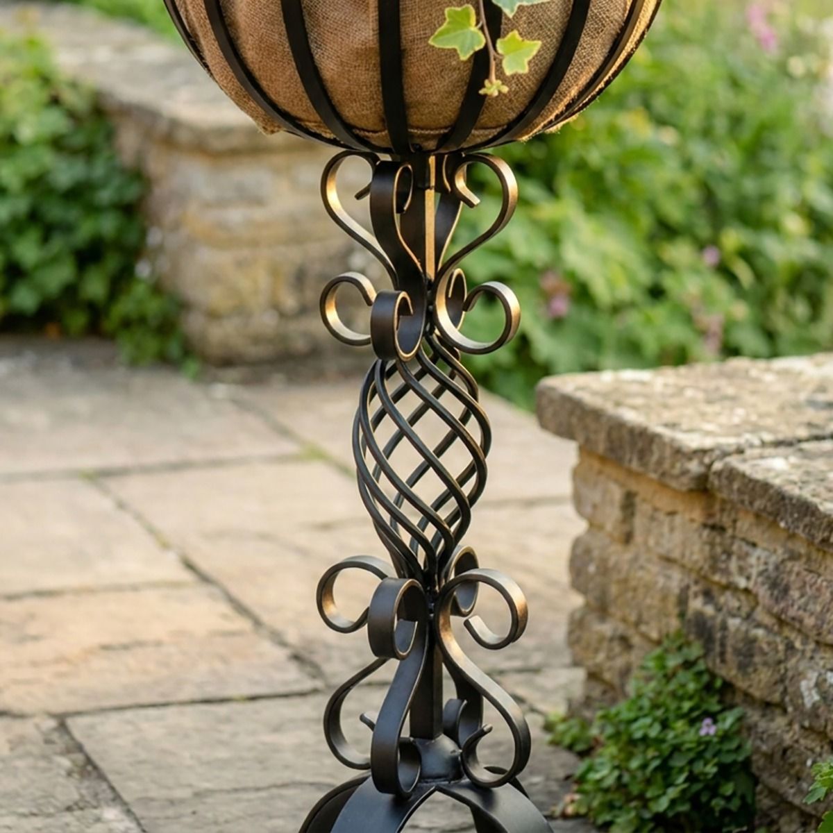 The "Stretton" Victorian Wrought Iron Basket Planter Stand in a Black Finish Showing a Close up of the Detailed and Decorative Spiral Scrollwork on the Base - Digital Illustration 