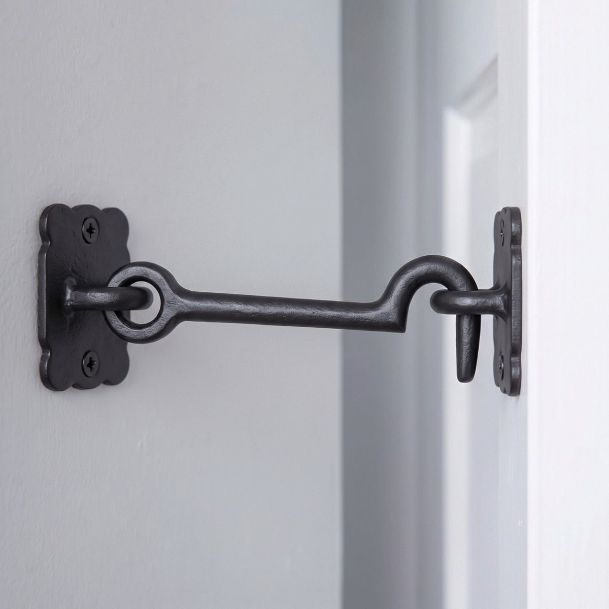 The Traditional Black Iron 3" Loose Ring Cabin Hook in a Modern Home on a White Door - Digital Illustration