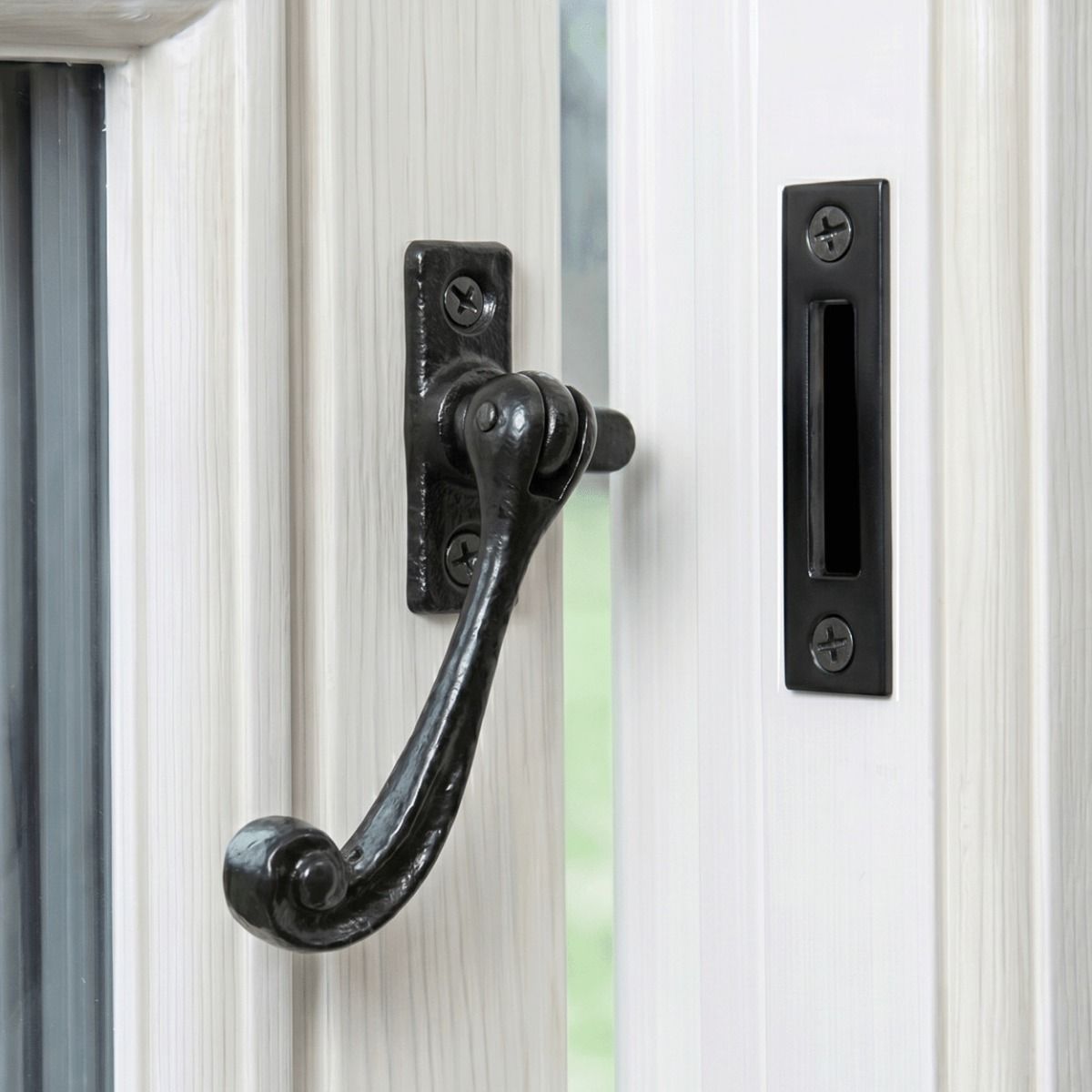 The Traditional Black Iron Window Casement Stay With Mortice Plate Mounted on a White Window Frame - Digital Illustration