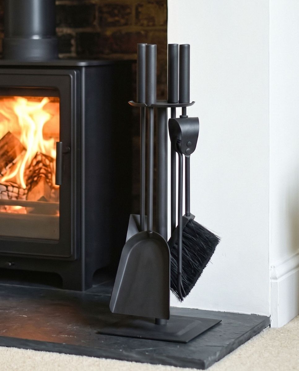 The Traditional Black Slim Three Piece Companion Set next to a Traditional Log Burner Stove in a Modern Home - Digital Illustration