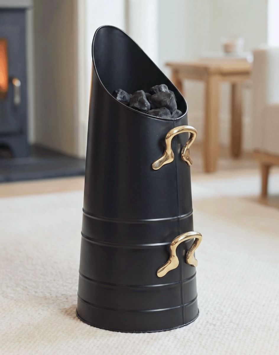The Traditional Norfolk Coal Hod with Brass Handles Placed in a Contemporary Living Room with a Lit Log Burner Behind - Digital Illustration