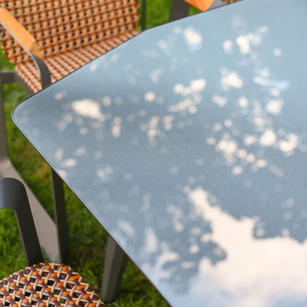 The Tribeca Weave 8-Piece Patio Dining Set Showing a Close up of the Glass Table Top