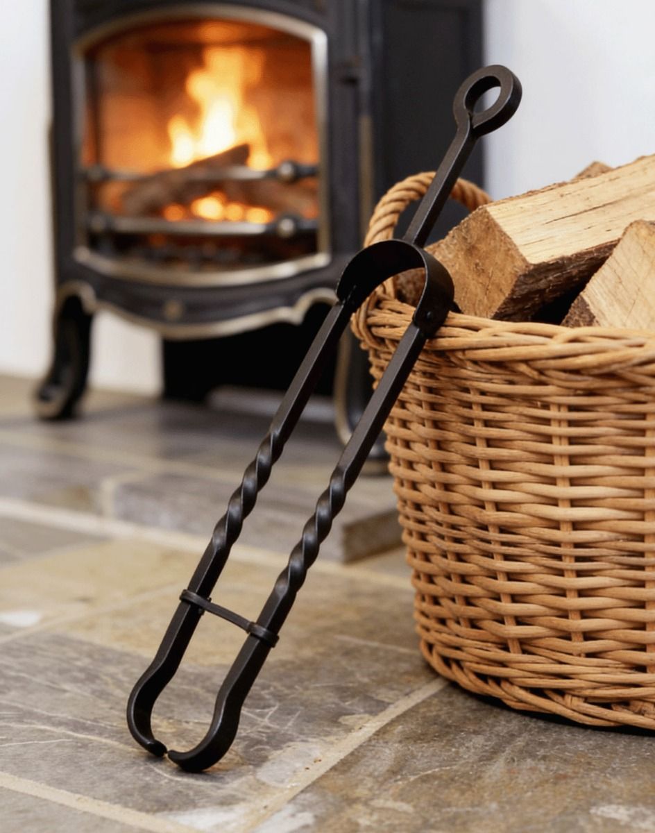 The Wrought Iron Tongs with Safety Clip on a Stone Tiled Cottage Floor in Front of a Lit Log Burner Stove - Digital Illustration