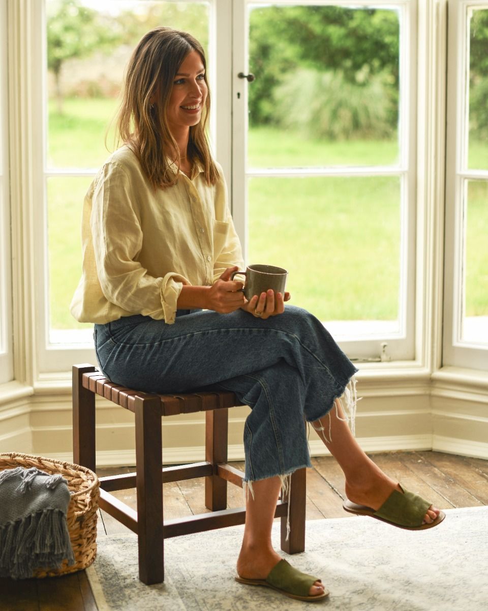 Person Sat on Traditional and Rustic Cross Hatch Brown Leather and Wood Stool for Scale