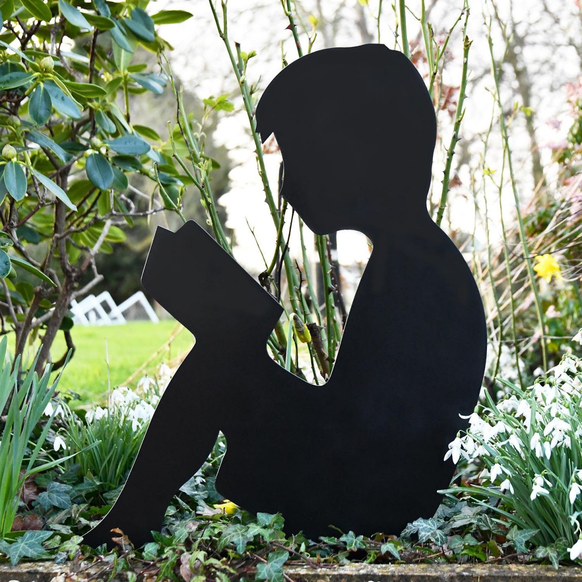 Metal Boy Reading Silhouette in situ in The Garden