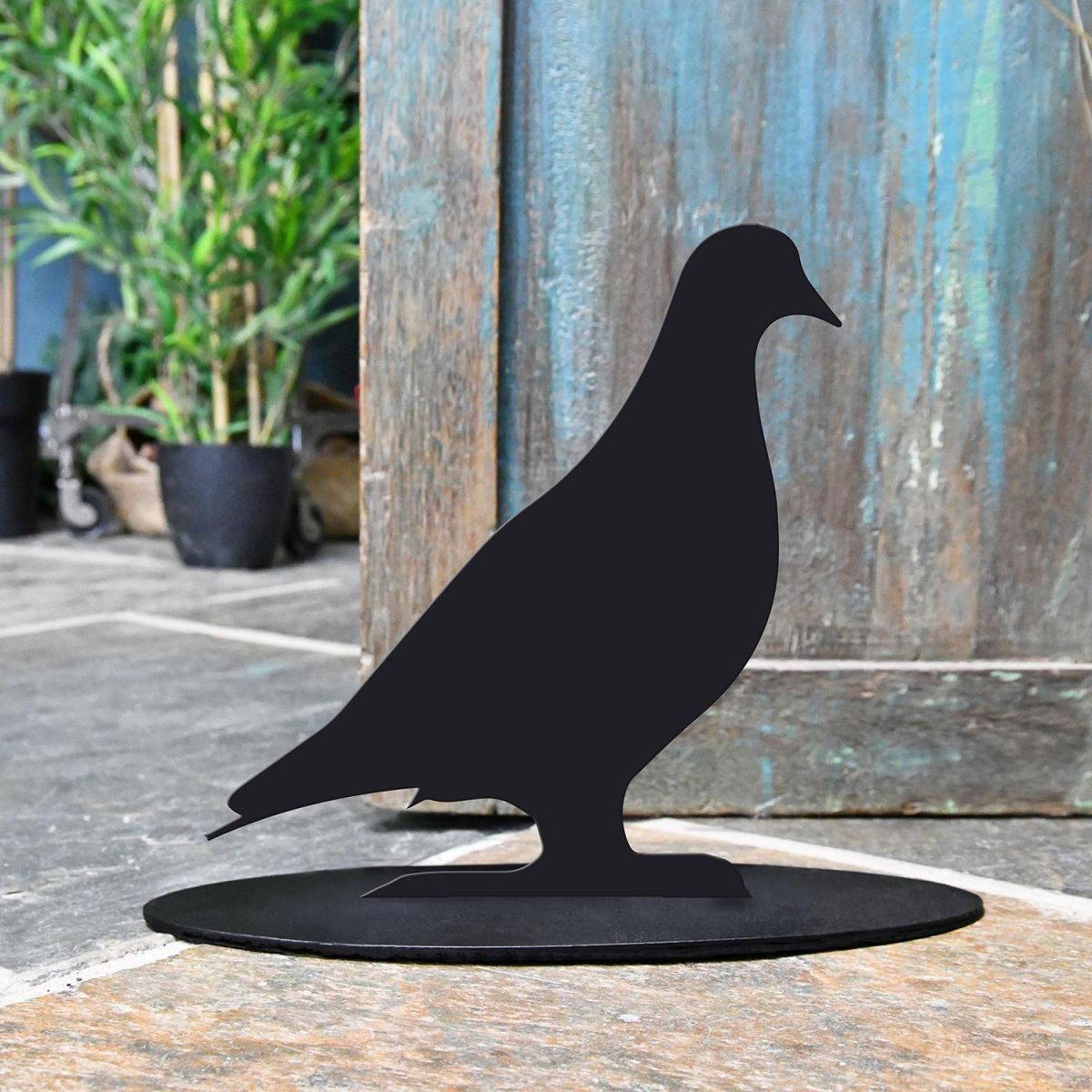 Pigeon Iron Door Stop Next to a Rustic Blue Door