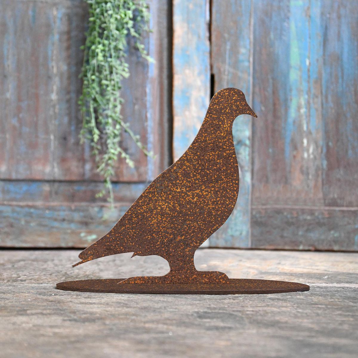 Pigeon Rustic Iron Door Stop in Front of a Rustic Blue Door Pigeon Rustic Iron Door Stop in Front of a Rustic Blue Door