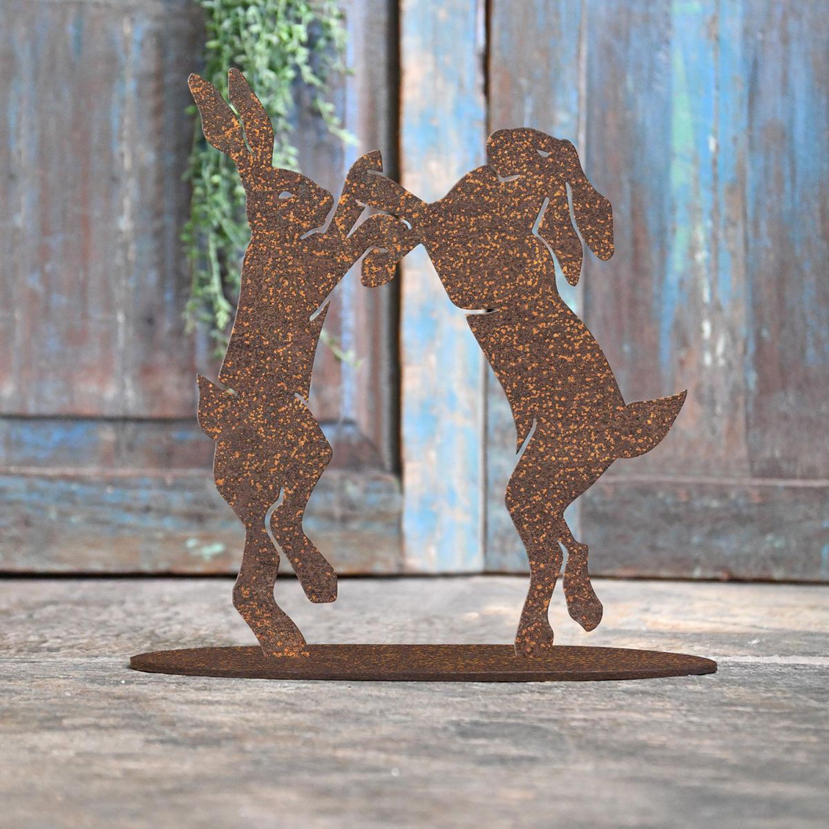 Boxing Hares Rustic Iron Door Stop in Front of a Rustic Blue Door