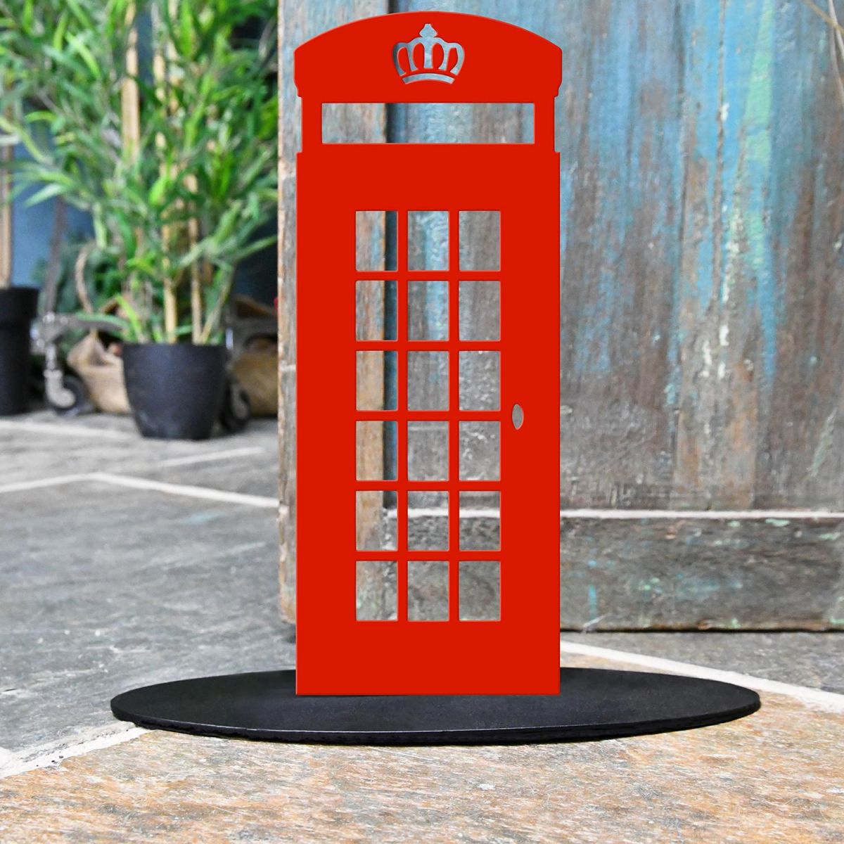 Red Telephone Box Iron Door Stop Next to a Rustic Blue Door