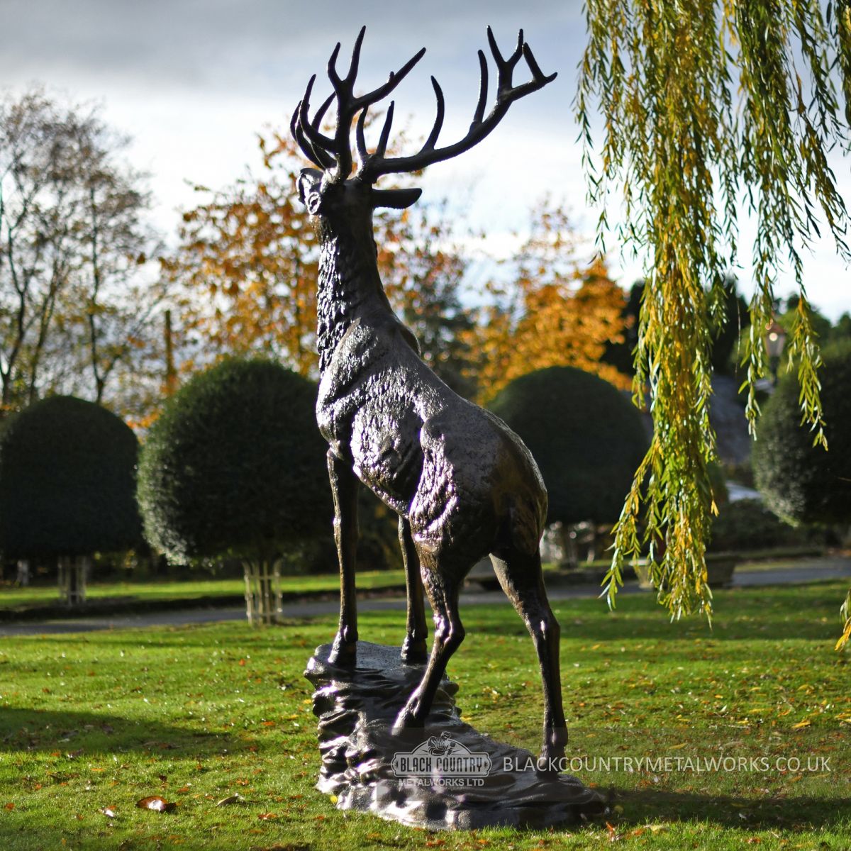 giant stag standing on rock in estate garden