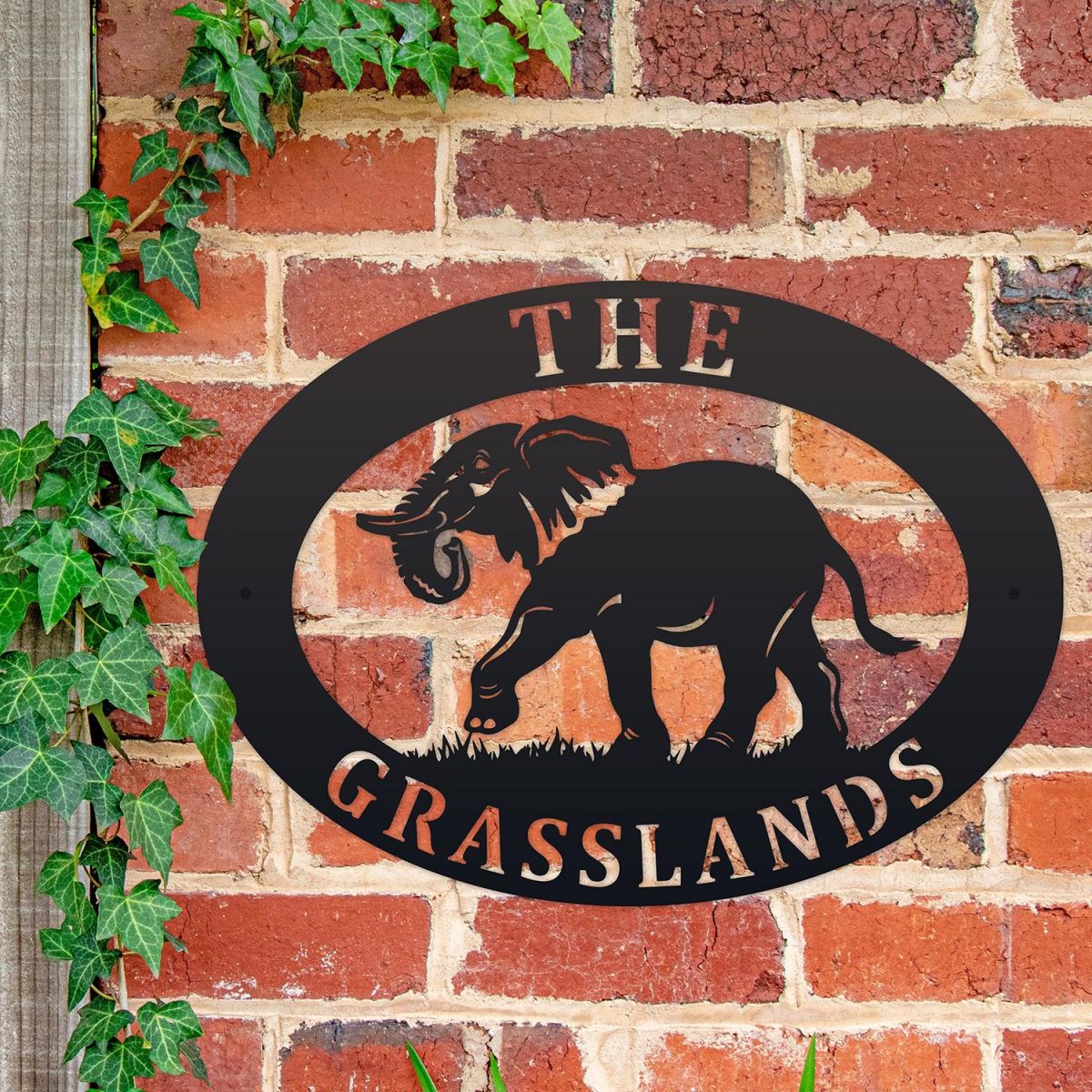 Elephant Iron Oval House Sign on a Brick Wall
