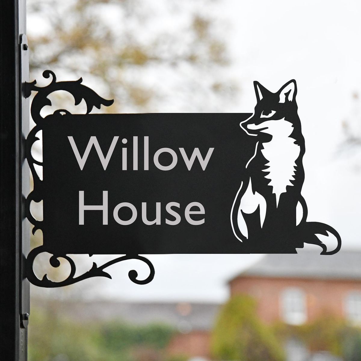 Sitting Fox Iron Bracket Name Sign in Front of a Home