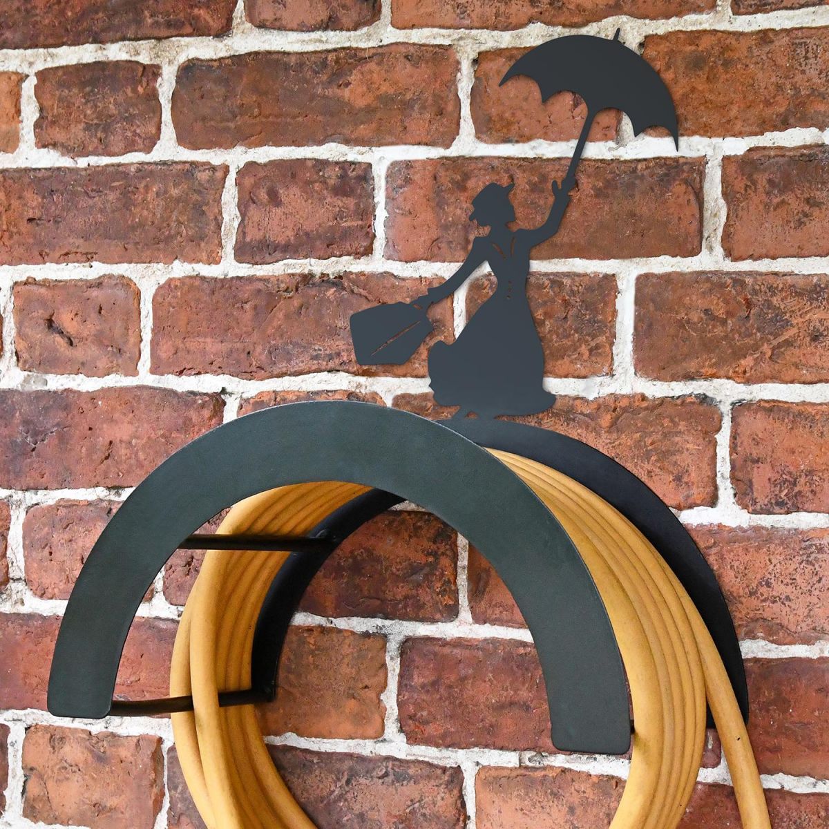 Wall Mounted Mary Poppins Iron Hose Holder Mounted to a Brick Wall