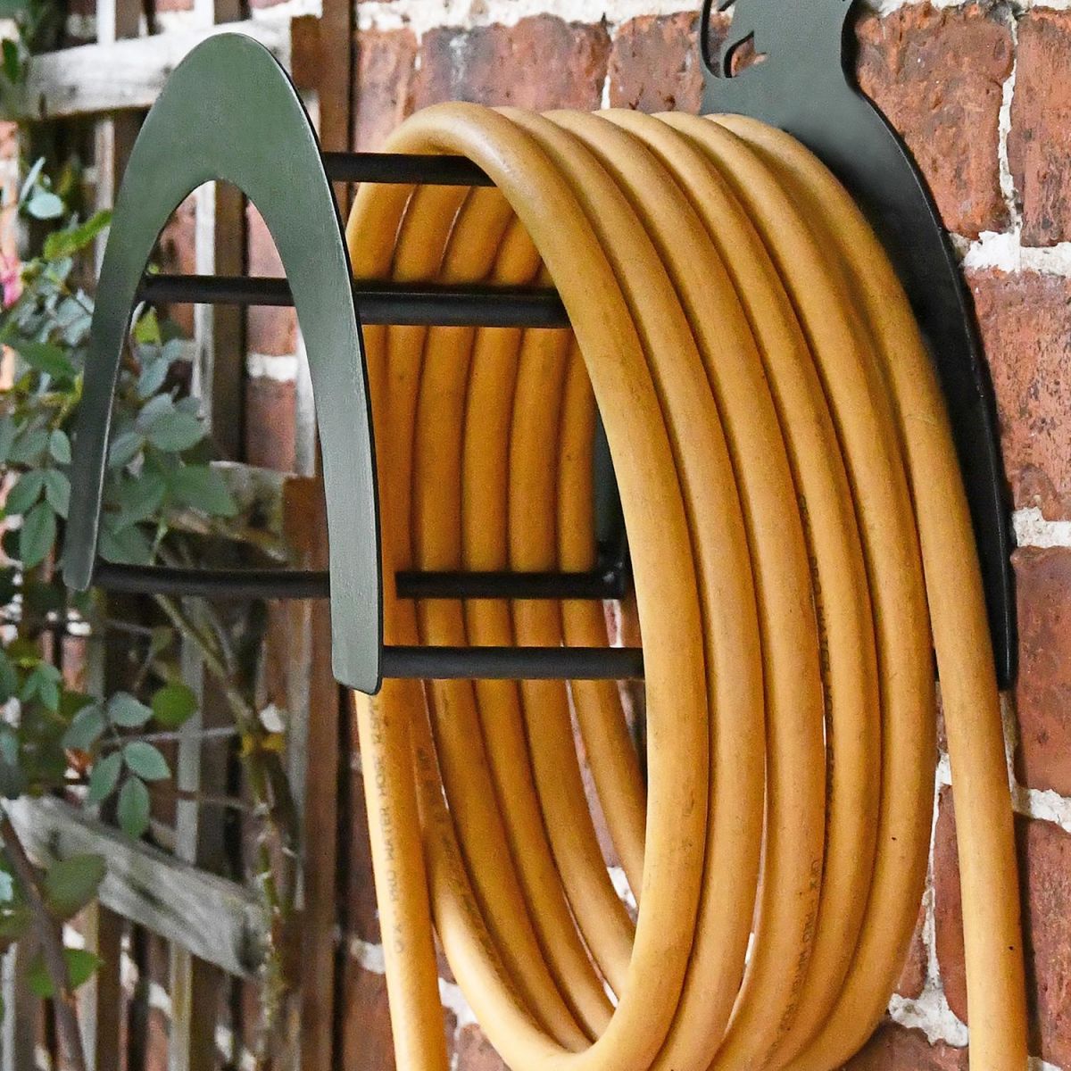 Side View of the Wall Mounted Mary Poppins Iron Hose Holder Mounted to a Brick Wall