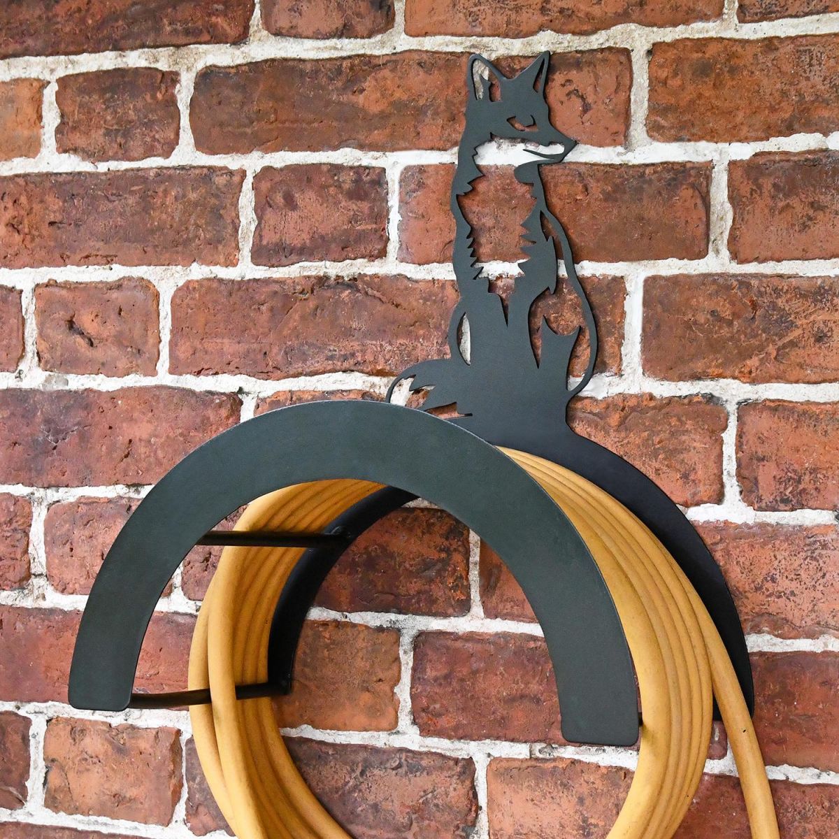 Wall Mounted Sitting Fox Iron Hose Holder Mounted to a Brick Wall