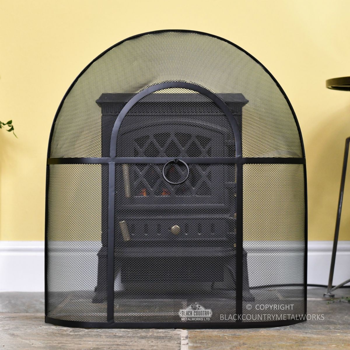 Black Arched Fire Guard In Front Of Stove