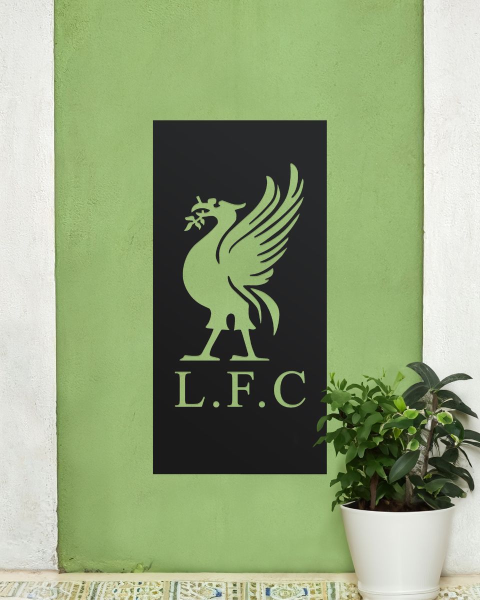 Black "Liver Bird Wall Art" on a green garden wall next to a potted plant Black "Liver Bird Wall Art" on a green garden wall next to a potted plant