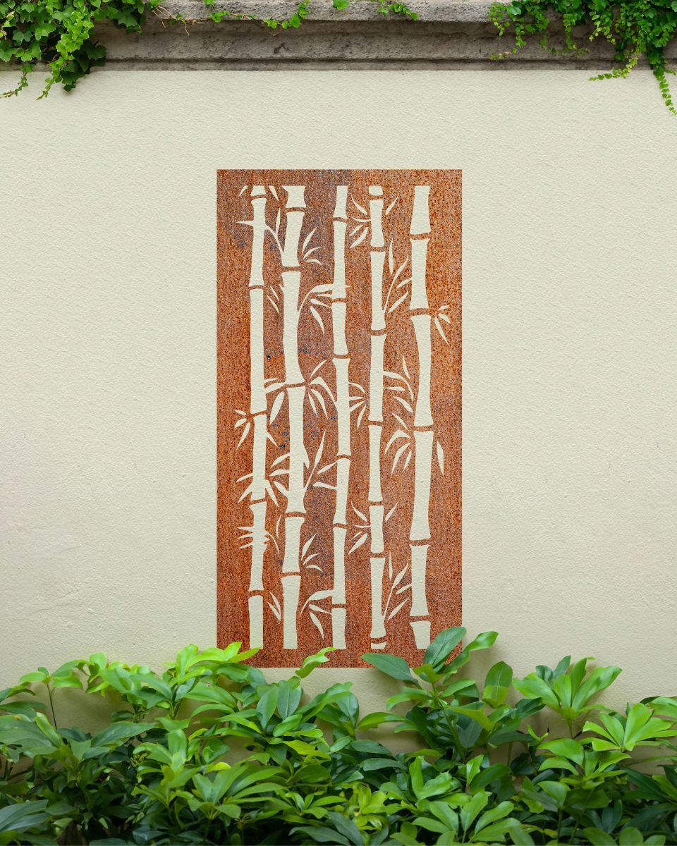 Rust Finish "Bamboo Garden Wall Art" on a cream garden wall surrounded by garden plants