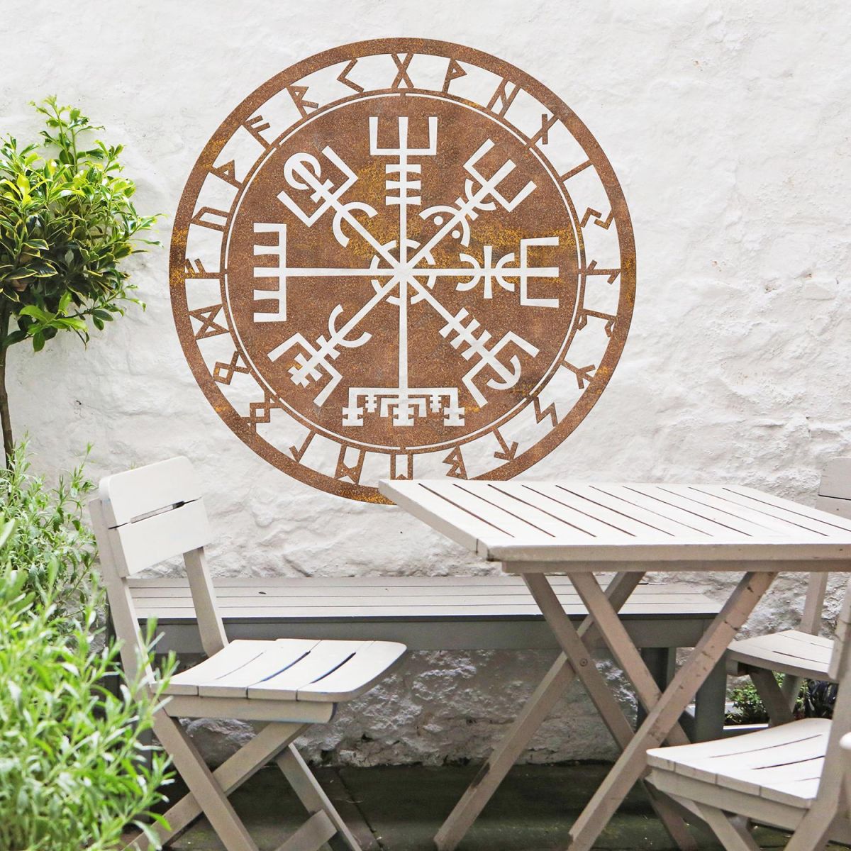 "Vegvisir" Viking Compass Wall Art in the Garden Above a Wooden Table & Chair Set "Vegvisir" Viking Compass Wall Art in the Garden Above a Wooden Table & Chair Set
