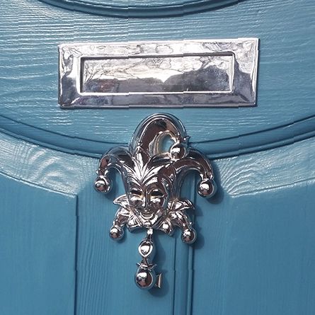 Bright Chrome Jester door knocker on Blue door