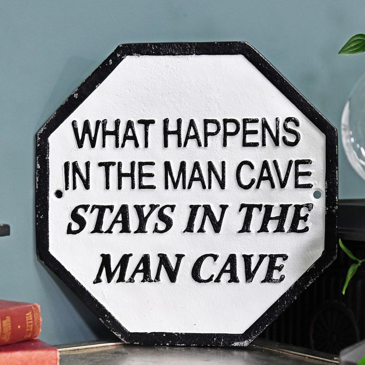 "What Happens In The Man Cave Stays In The Man Cave" Cast Iron Sign in Situ on a Blue Wall