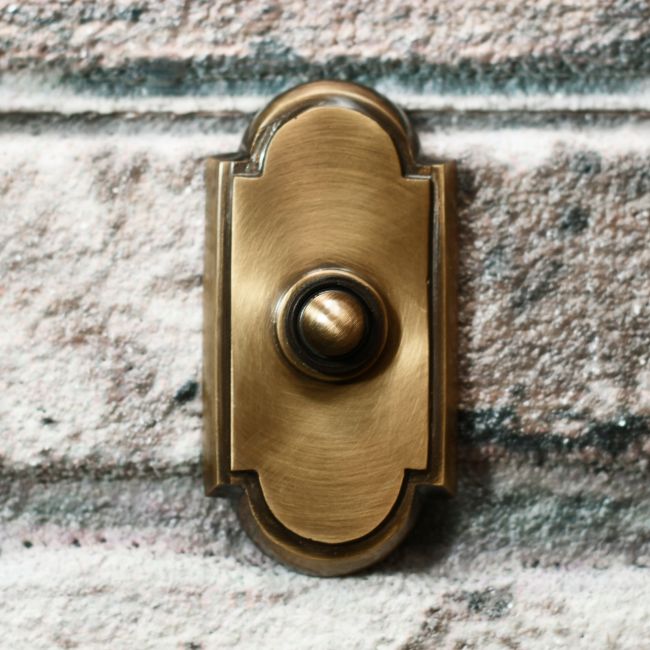 Antique Bronze Bell Push with arch on brick wall Antique Bronze Bell Push with arch on brick wall