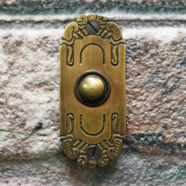 Art Nouveau inspired door bell on brick wall Art Nouveau inspired door bell on brick wall