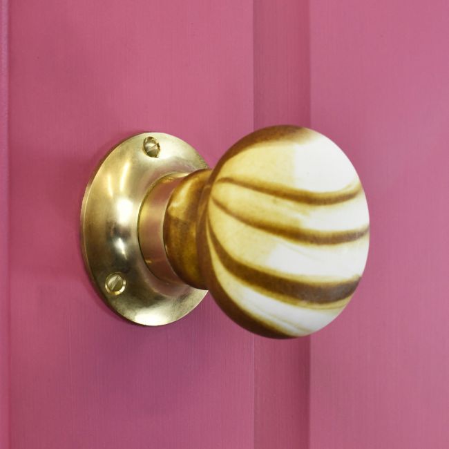 Stone Effect door knob on pink door with polished brass backplate Stone Effect door knob on pink door with polished brass backplate