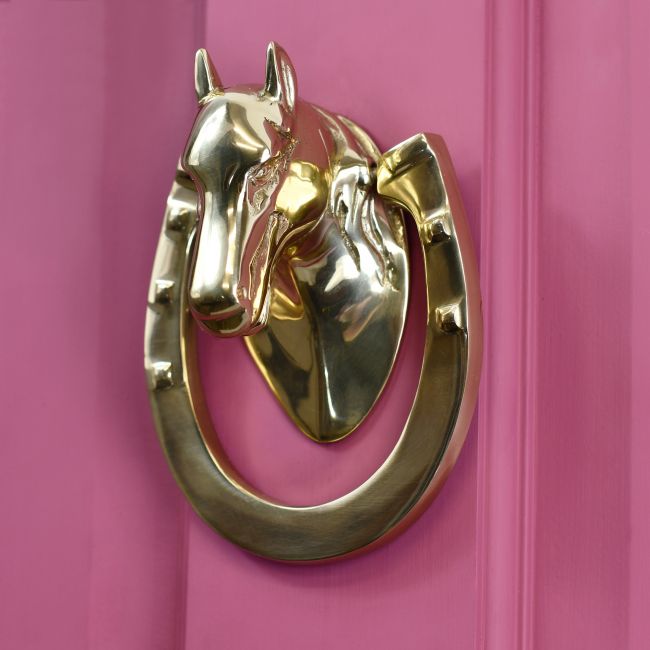 Polished Brass Horse & Shoe door knocker on pink door Polished Brass Horse & Shoe door knocker on pink door