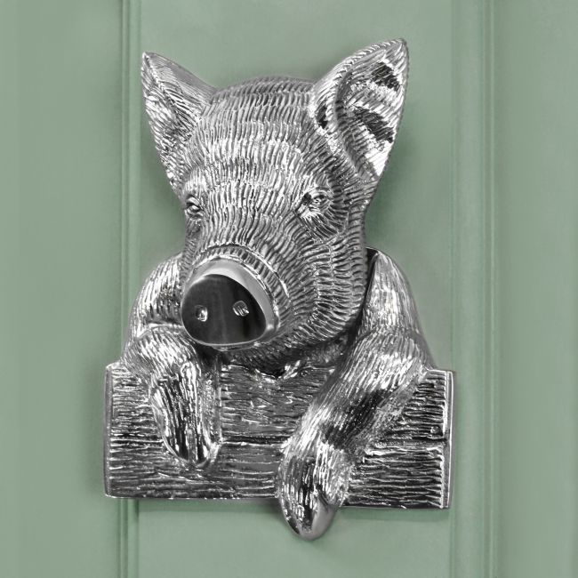 Bright Chrome Pig door knocker on green door Bright Chrome Pig door knocker on green door