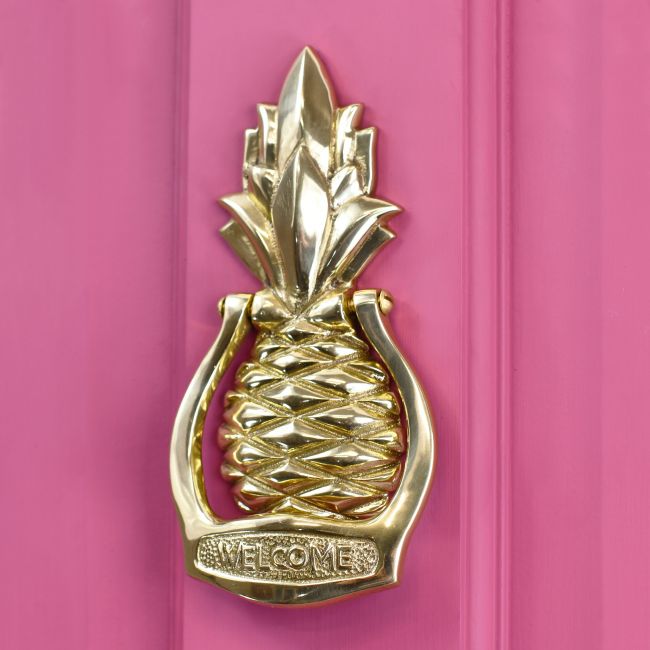 Brass Pineapple door knocker on pink door Brass Pineapple door knocker on pink door