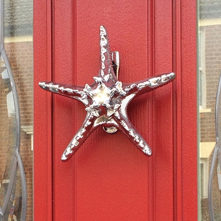 Bright Chrome Starfish Door Knocker on red door